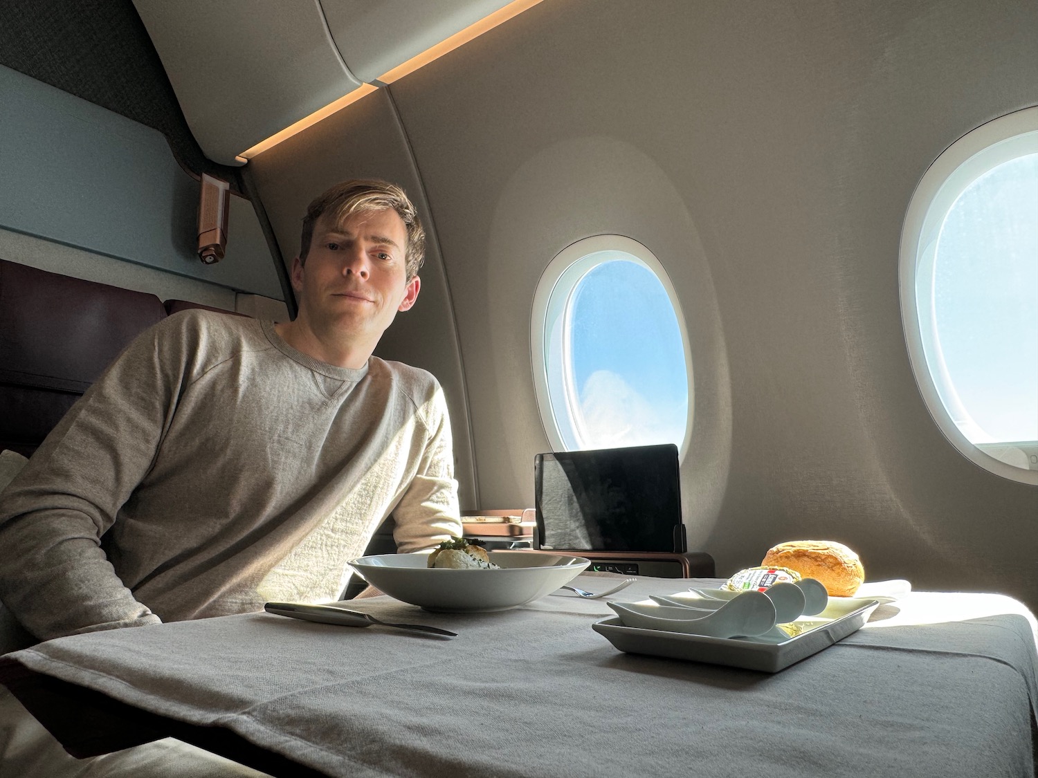 a man sitting at a table with food and a laptop