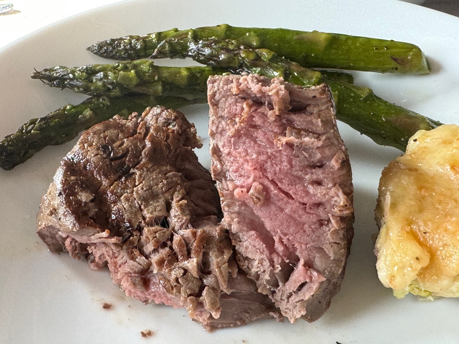 a plate of food with meat and asparagus