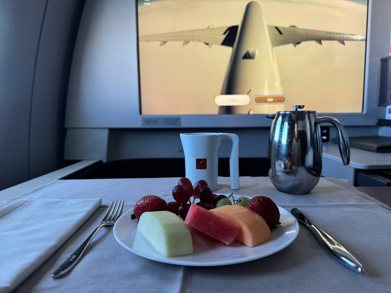 a plate of fruit and a coffee pot on a table