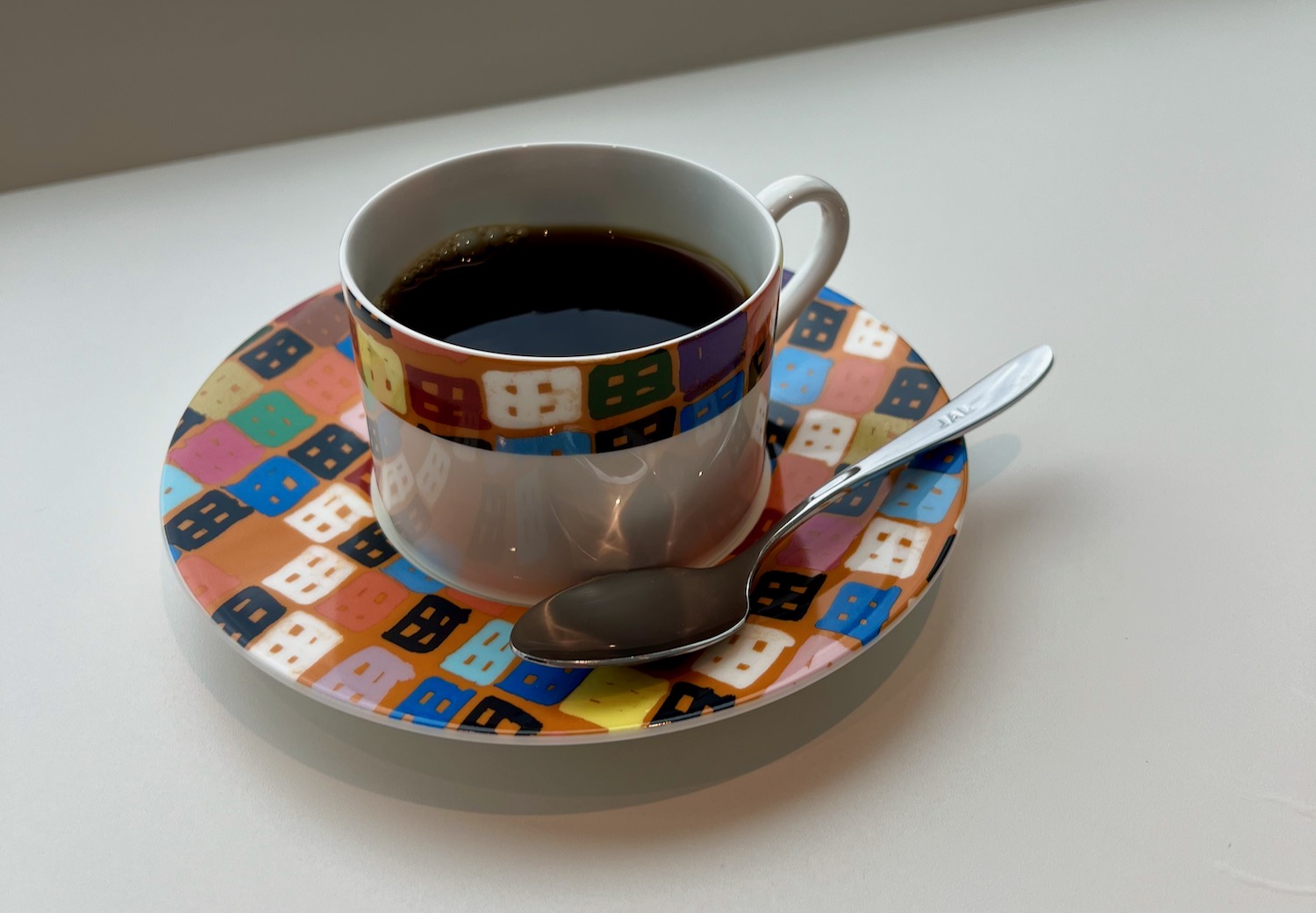 a cup of coffee with a spoon on a saucer