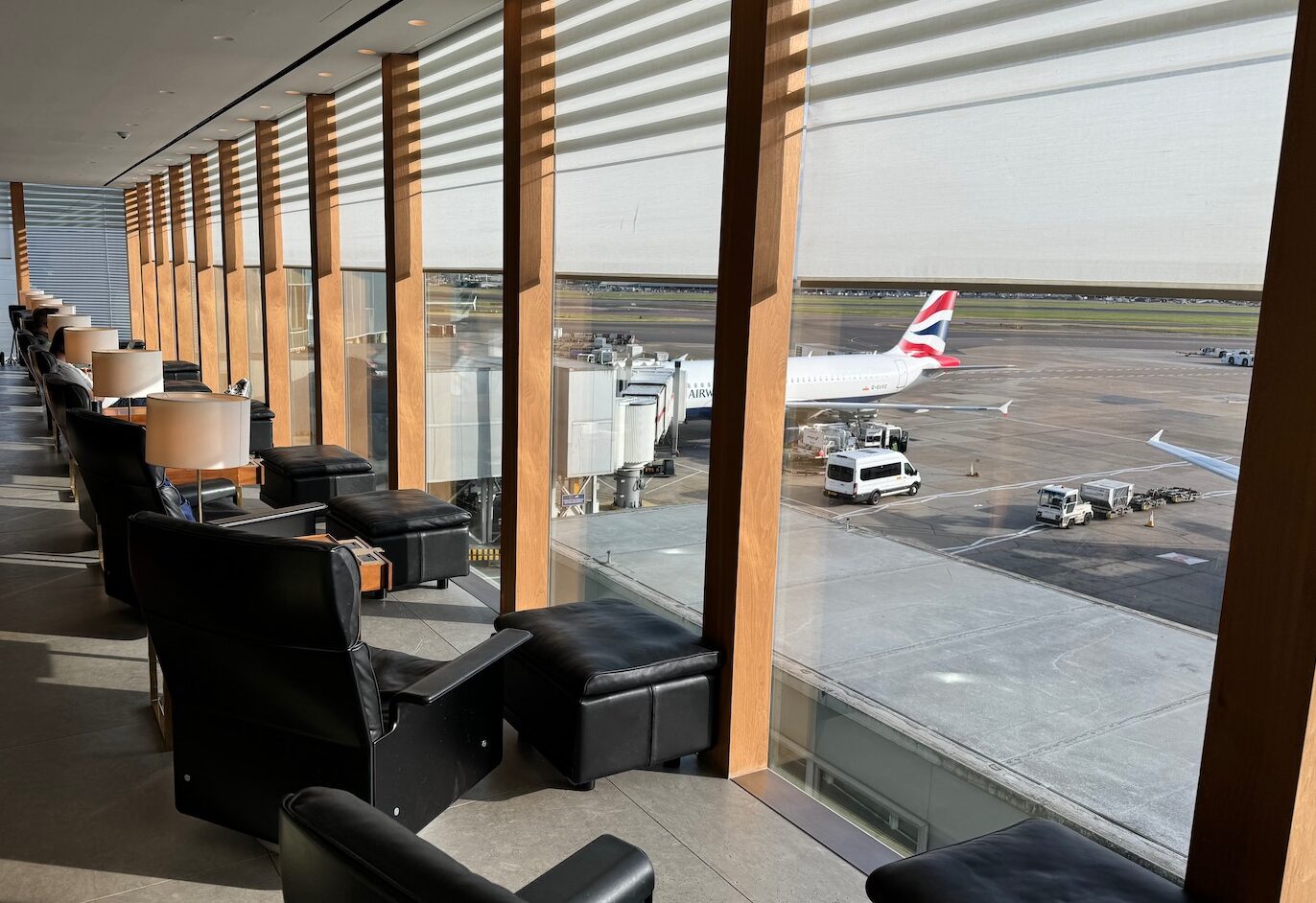 a room with a window and chairs and a plane in the background