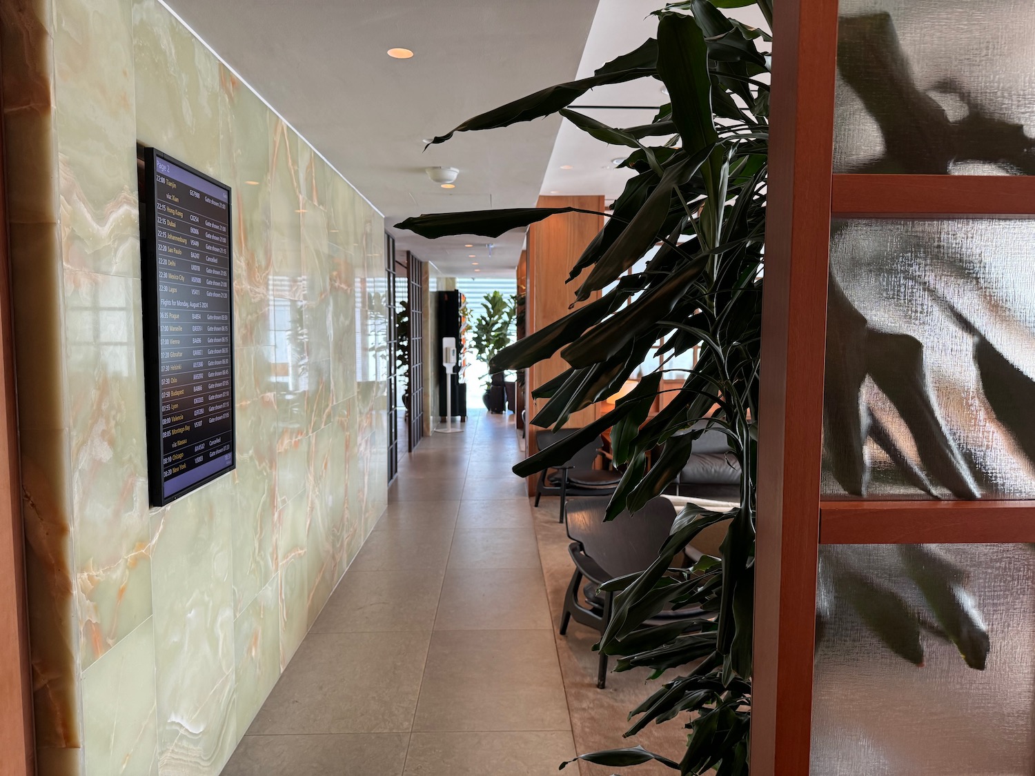 a long hallway with a plant and a screen on the wall