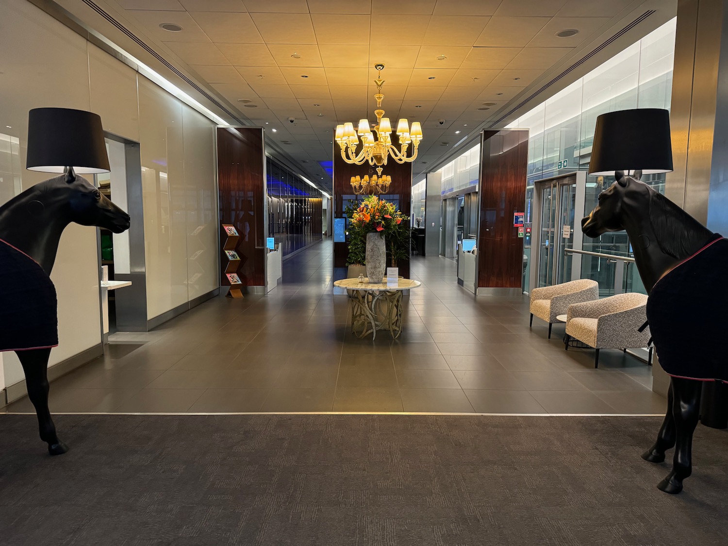 a large hallway with a horse head statue and chandelier