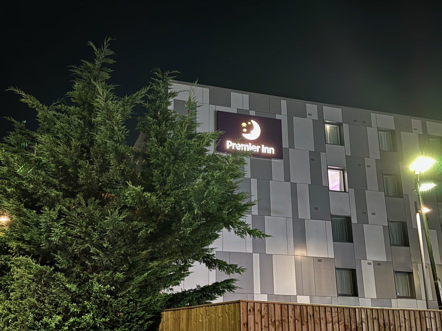 a building with a sign and a tree