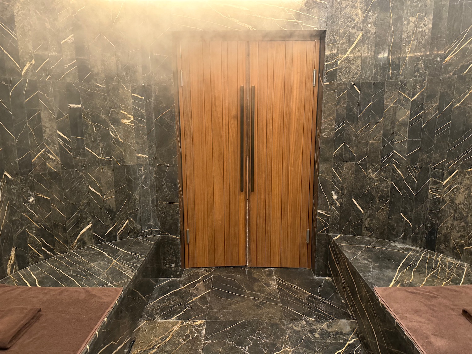 a wooden door in a room with marble walls