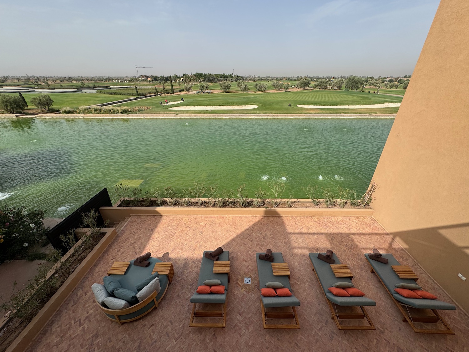 a group of deck chairs on a terrace overlooking a body of water