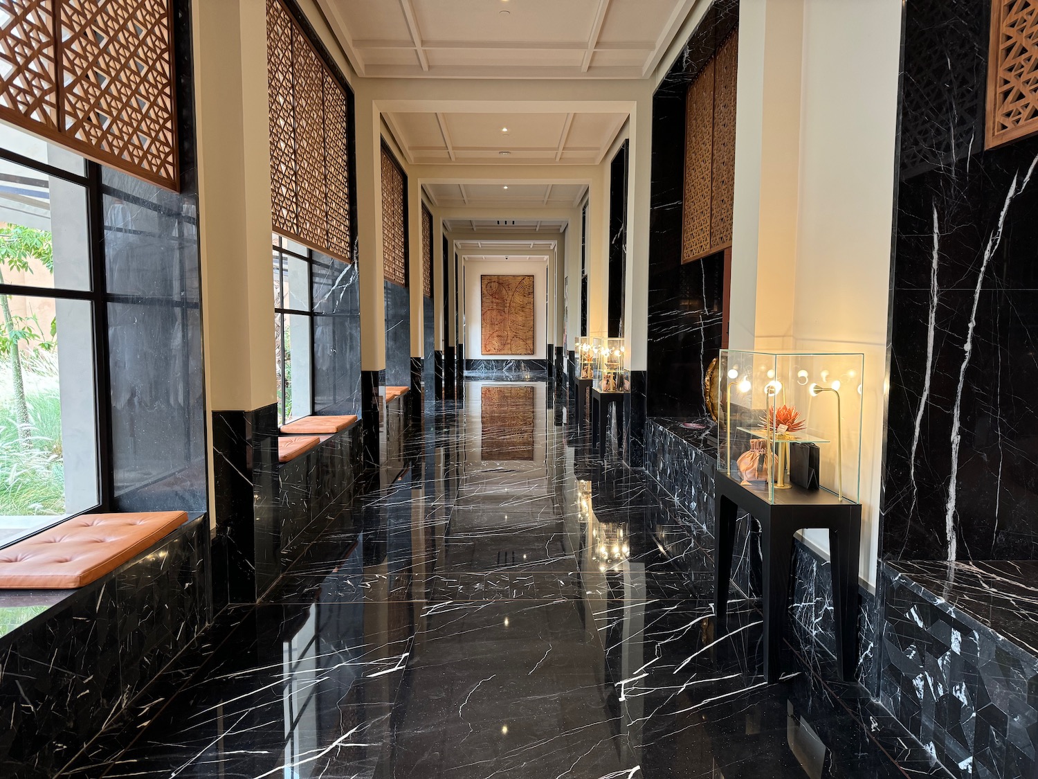 a hallway with black marble floor and white walls