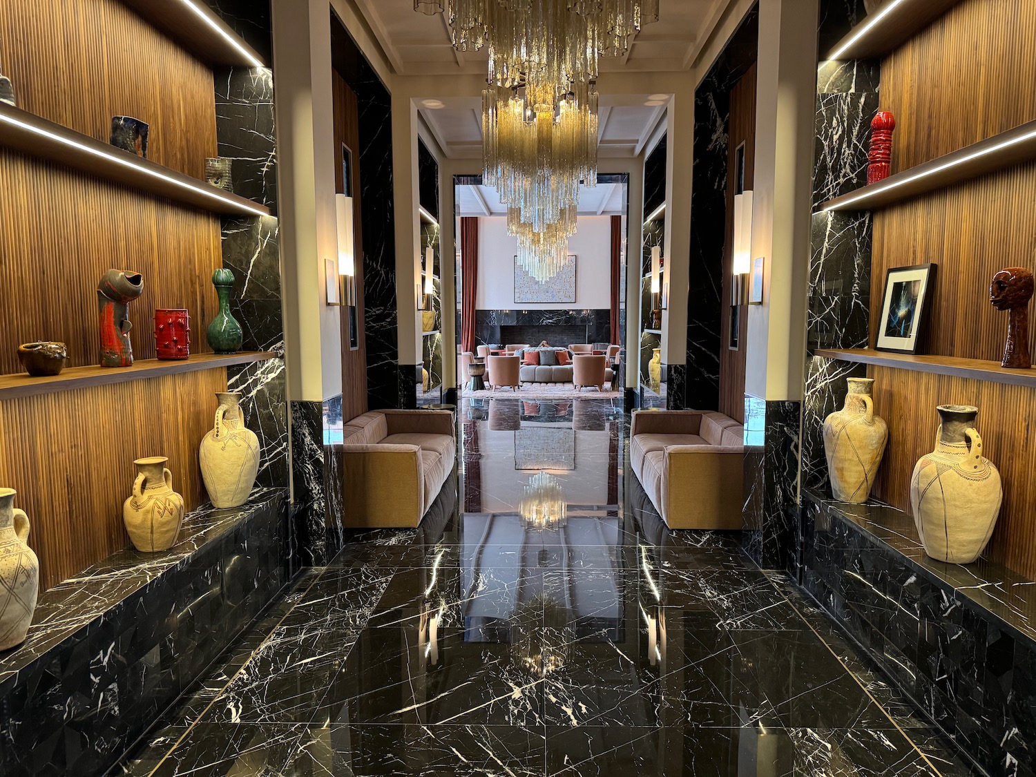 a hallway with chandelier and marble floor