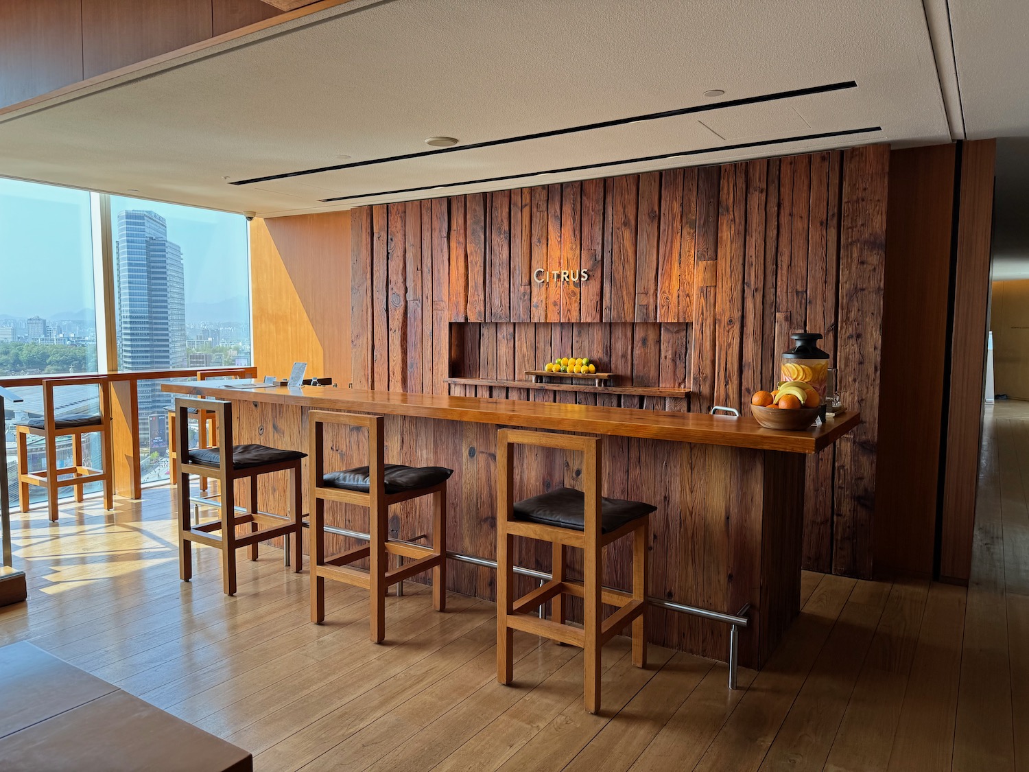 a bar with stools and a table in a room with a window