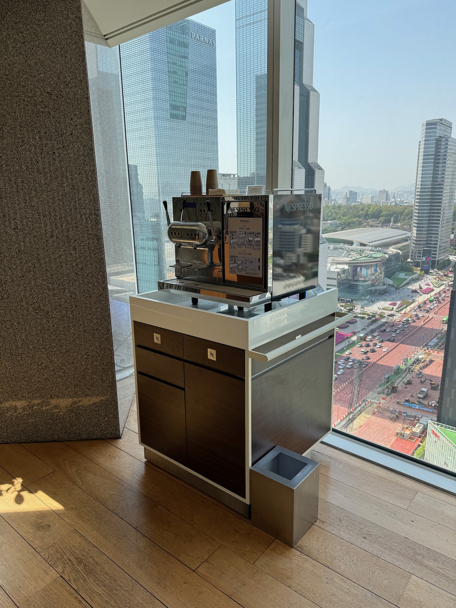 a coffee machine in a room with a window overlooking a city