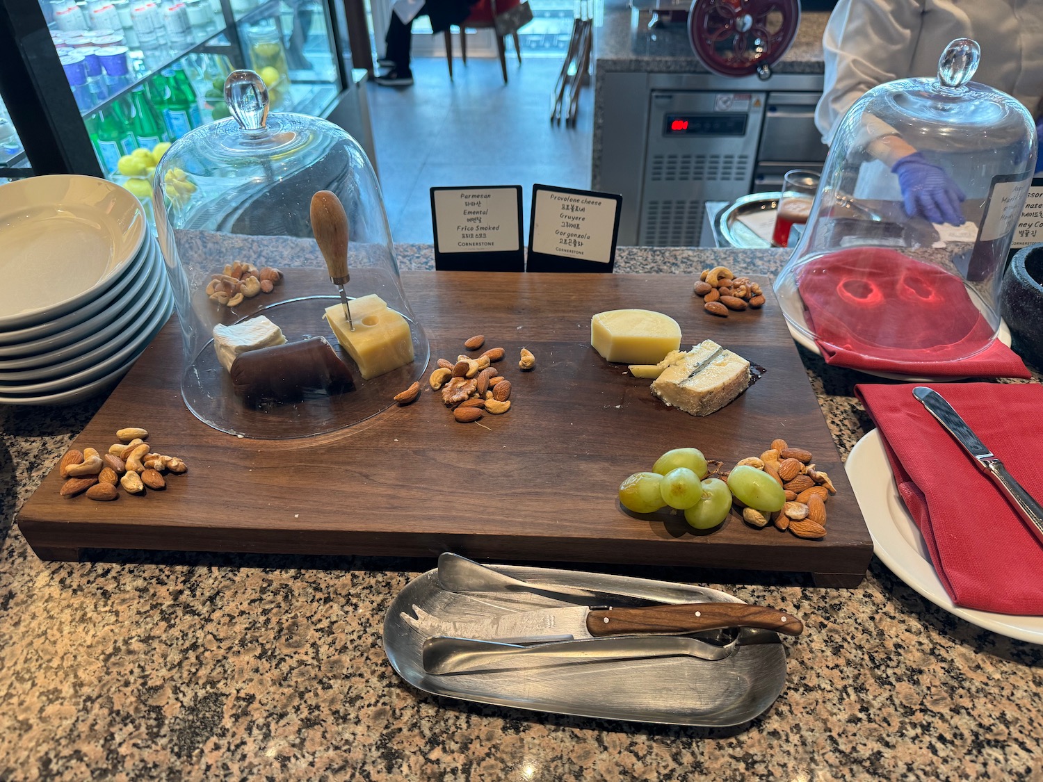 a cheese platter with nuts and grapes on a counter