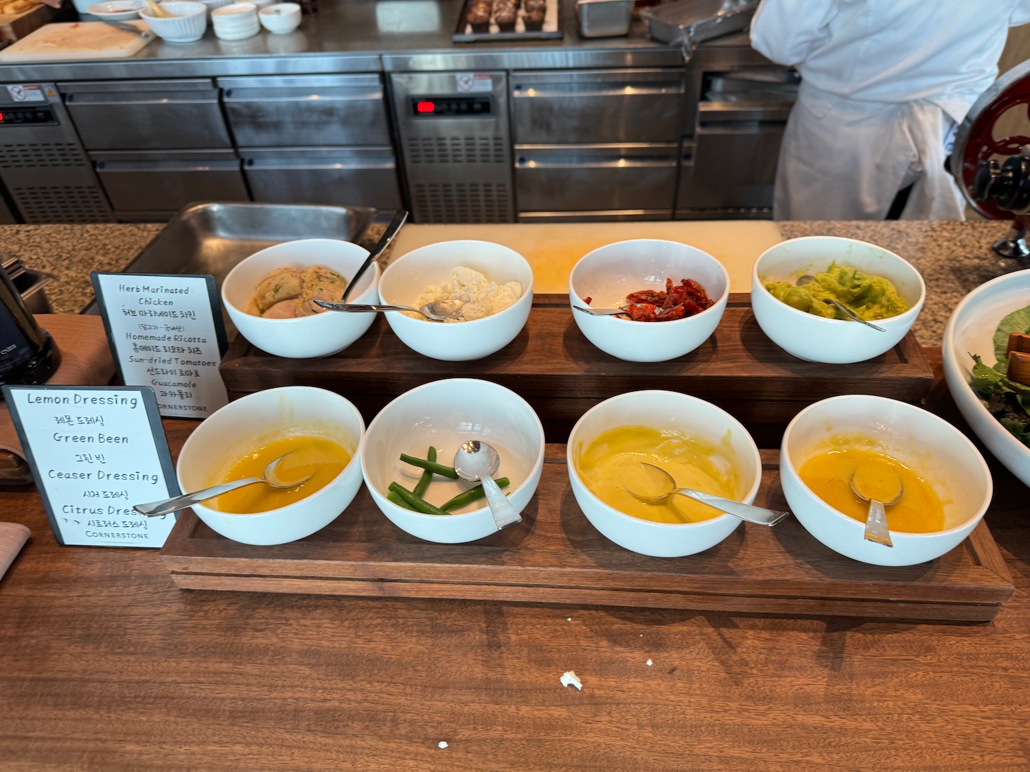 a row of bowls of food on a wooden table