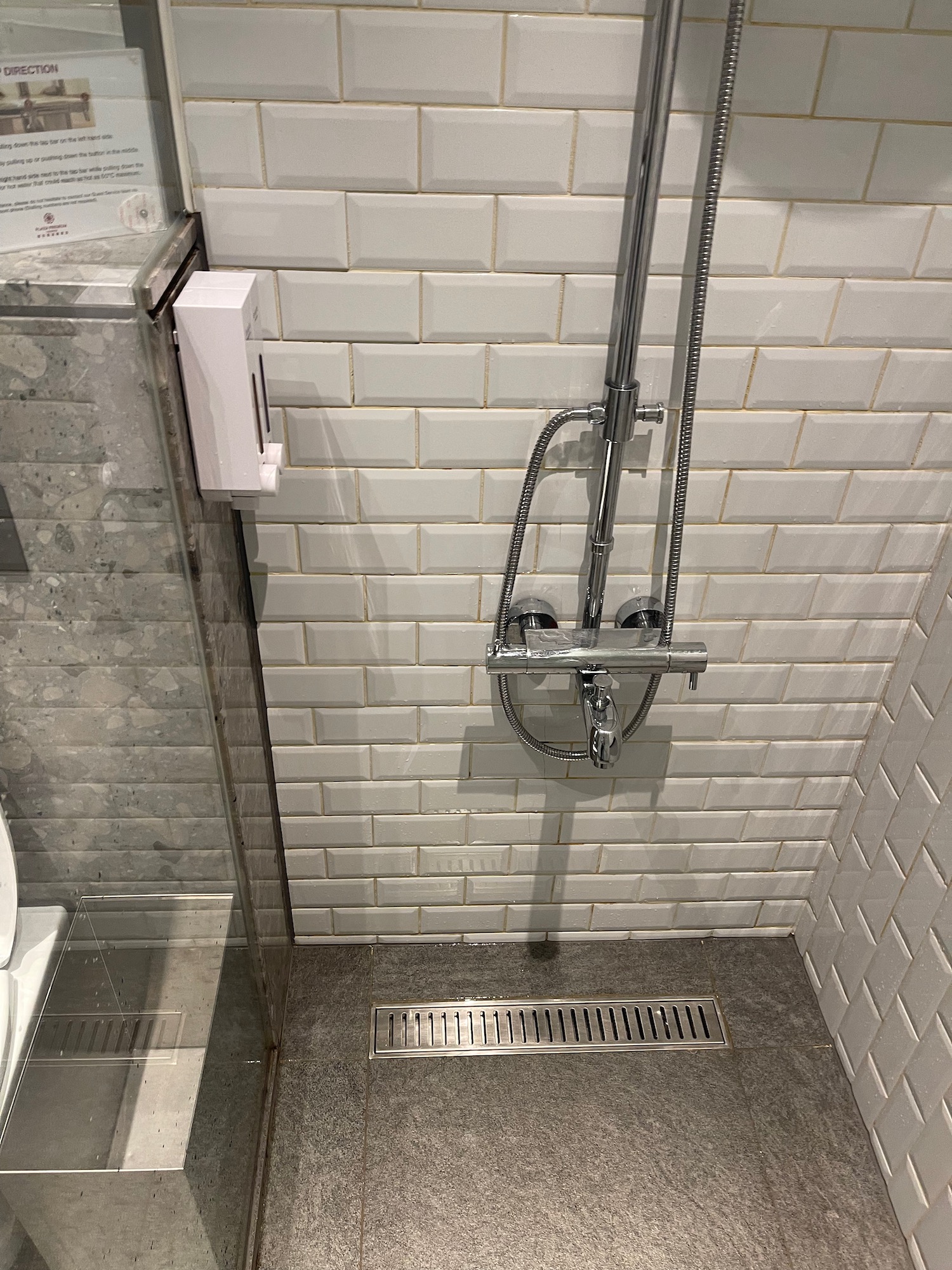 a shower with shower head and a toilet