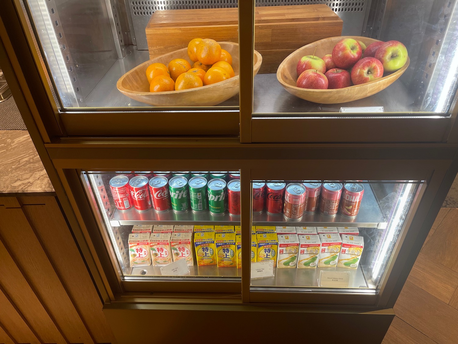 a glass display case with fruit and drinks