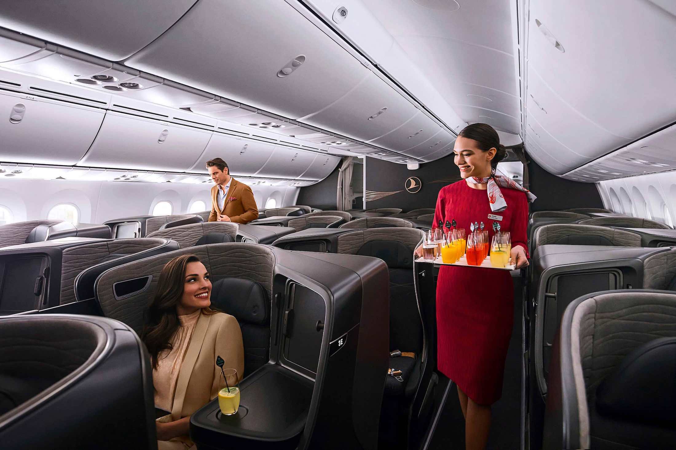 a woman holding a tray with drinks on the back of an airplane