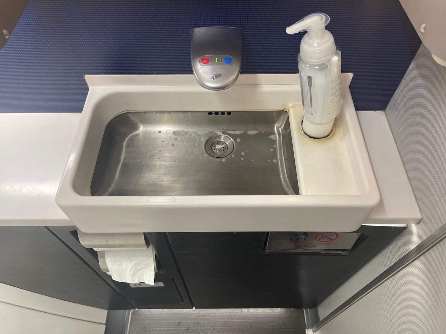 a sink with soap dispenser and a bottle