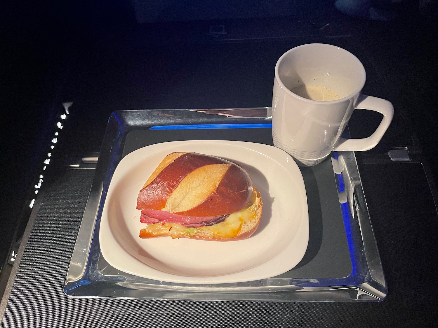 a sandwich on a plate and a cup of coffee