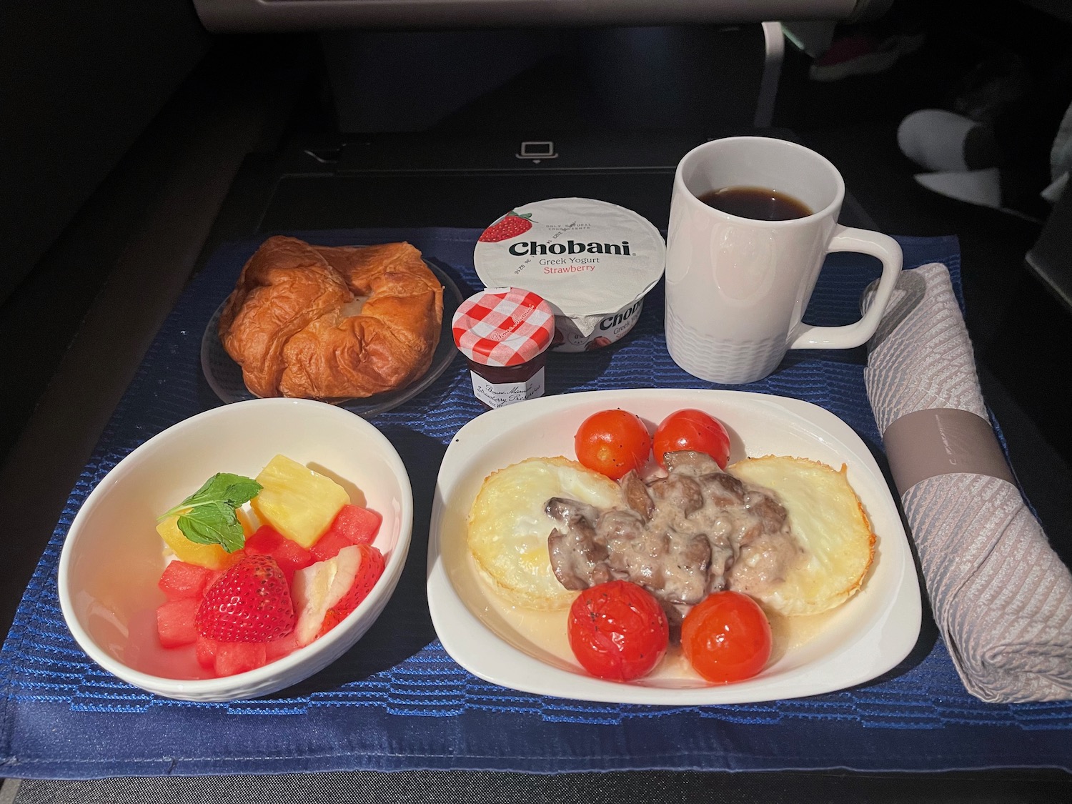 a plate of food and a cup of coffee on a blue surface