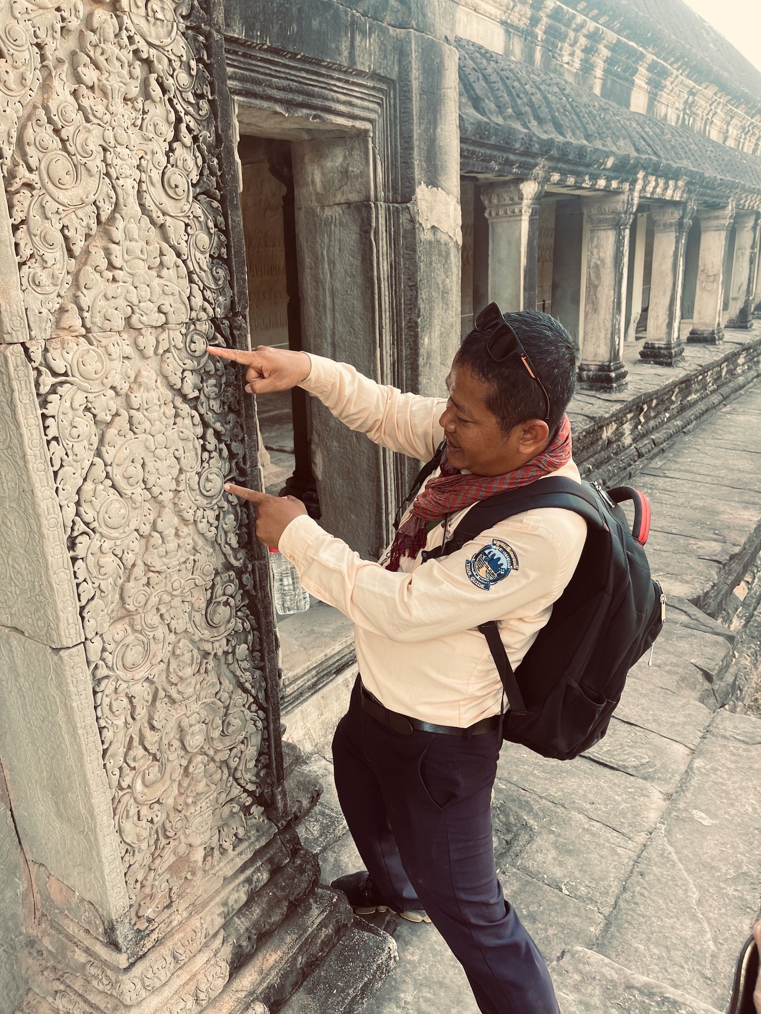 a man pointing at a stone wall