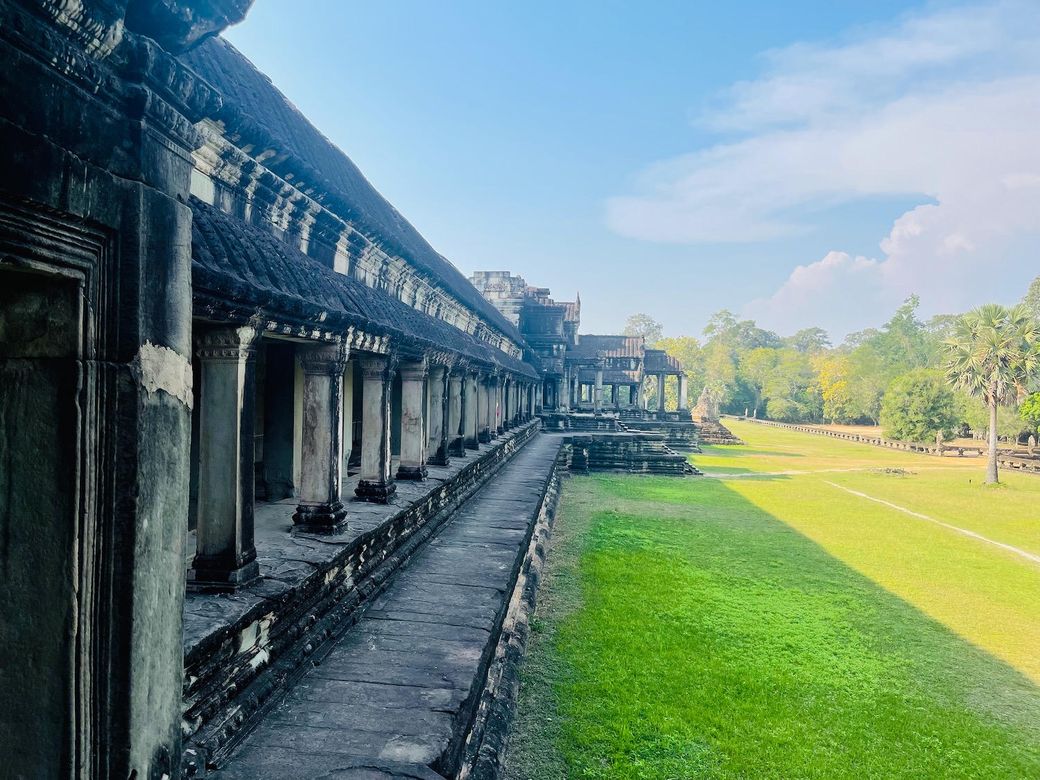 a row of stone buildings with columns and grass