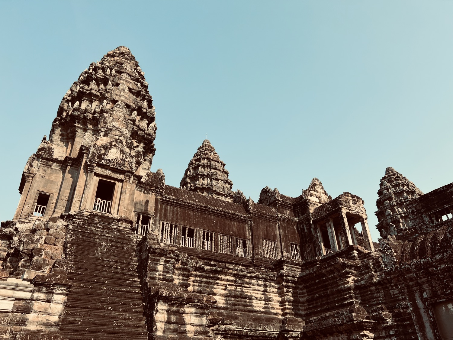 a stone building with towers with Angkor Wat in the background