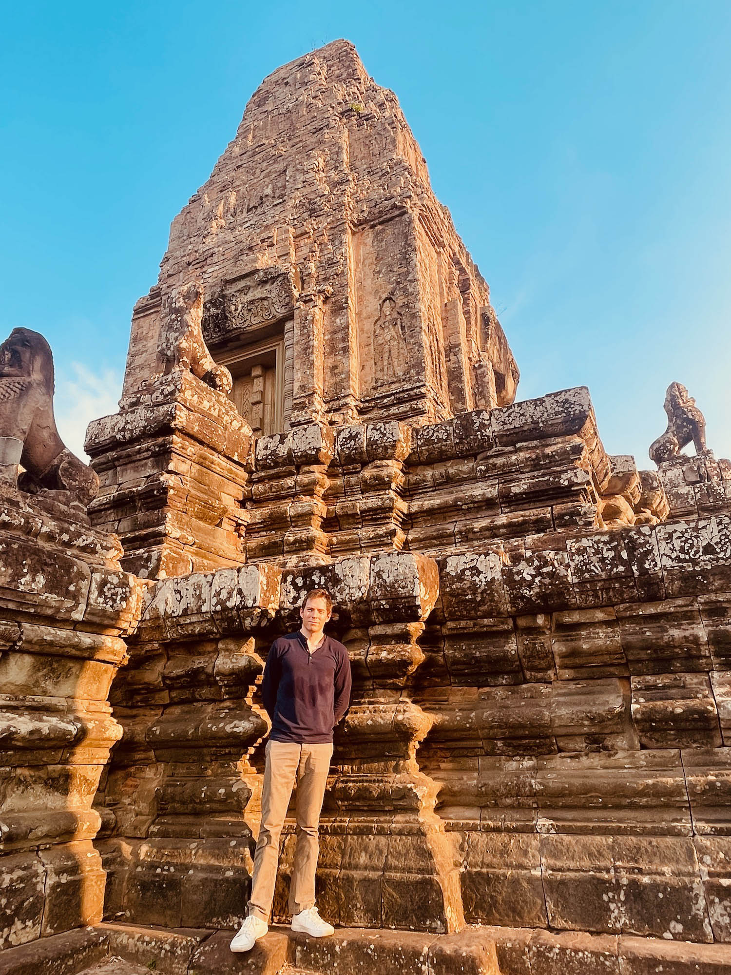 a man standing in front of a stone building