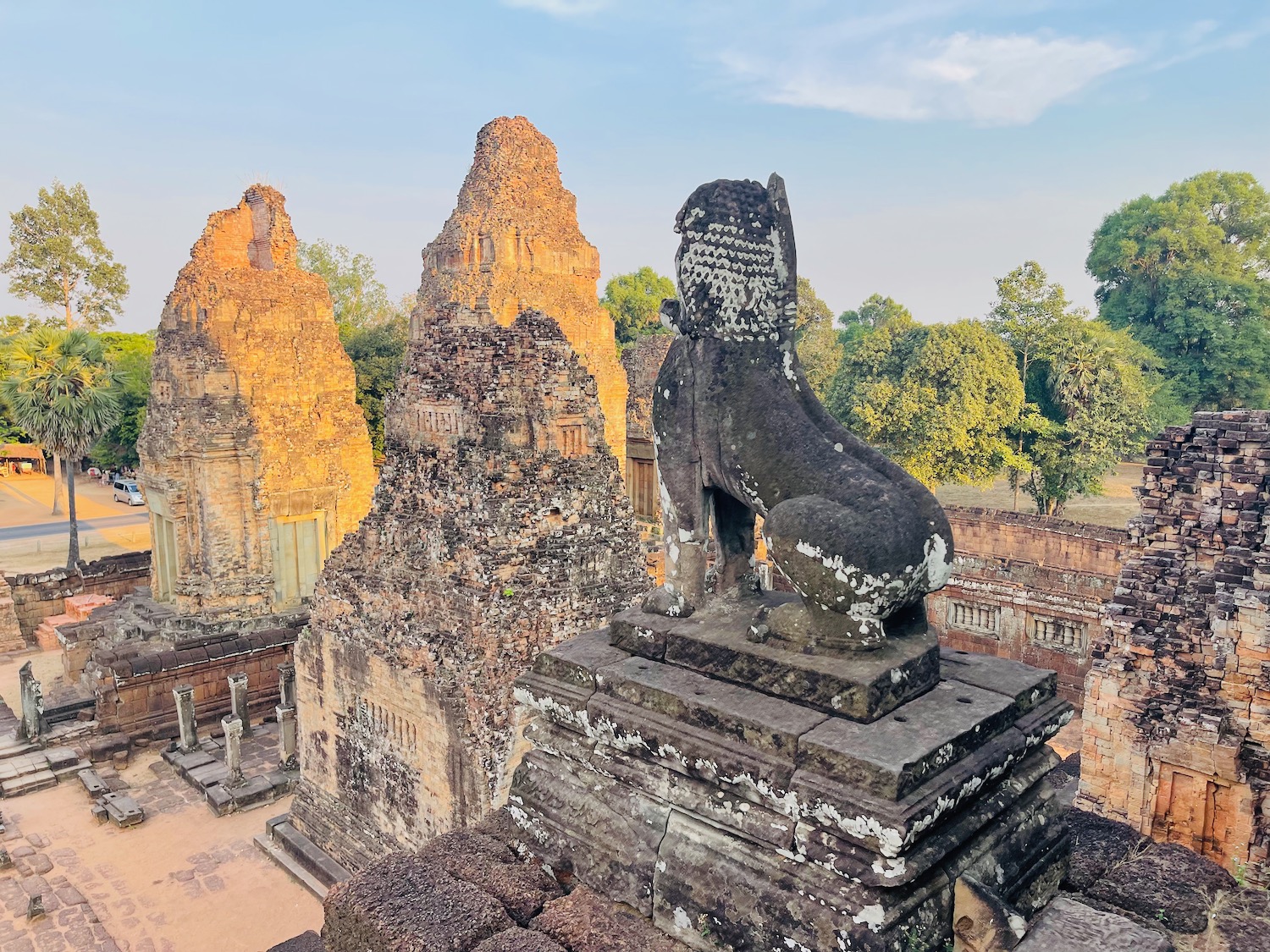 a stone lion statue on a platform with a group of towers