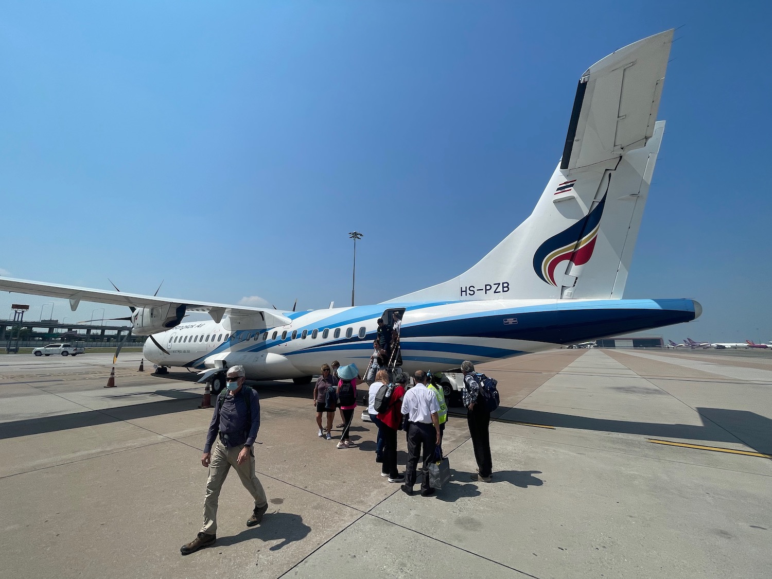 a group of people standing next to a plane