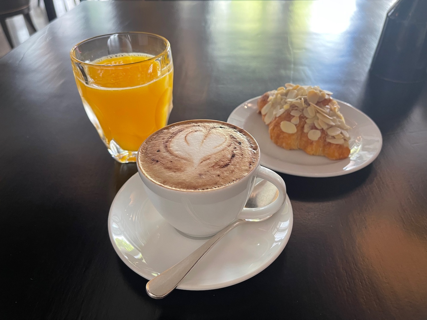 a cup of coffee and a croissant on a plate