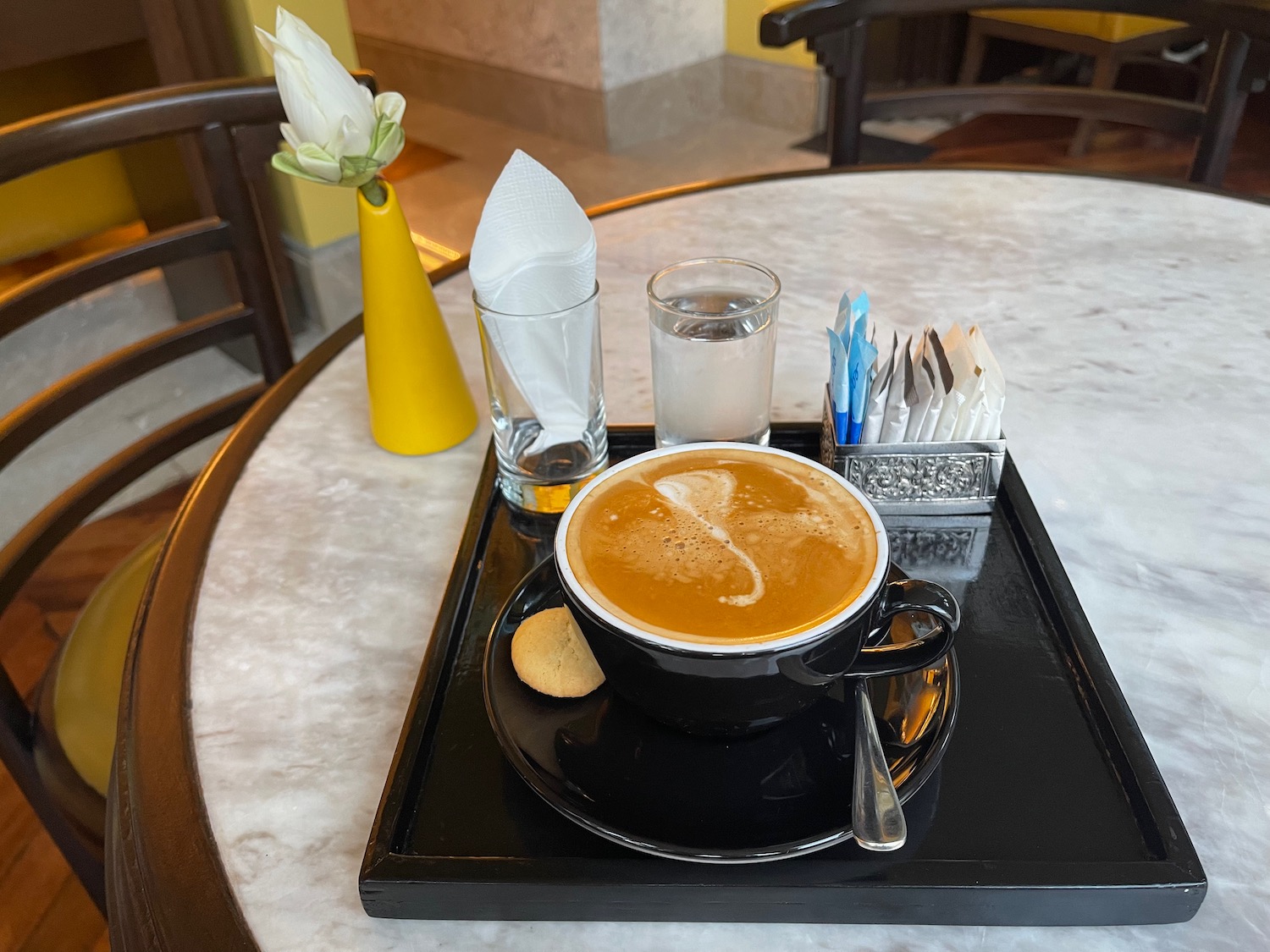 a cup of coffee and cookies on a tray