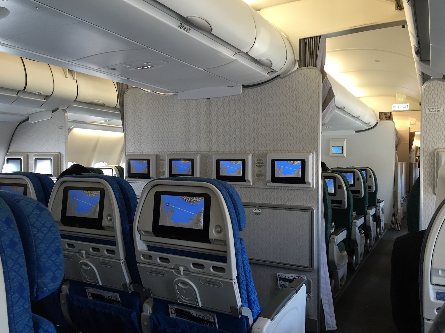 a row of seats with monitors on the wall