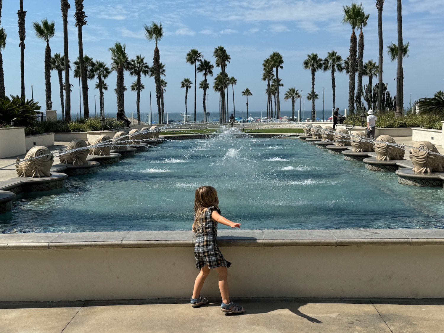 a child standing in front of a fountain