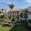 a building with palm trees and a lawn