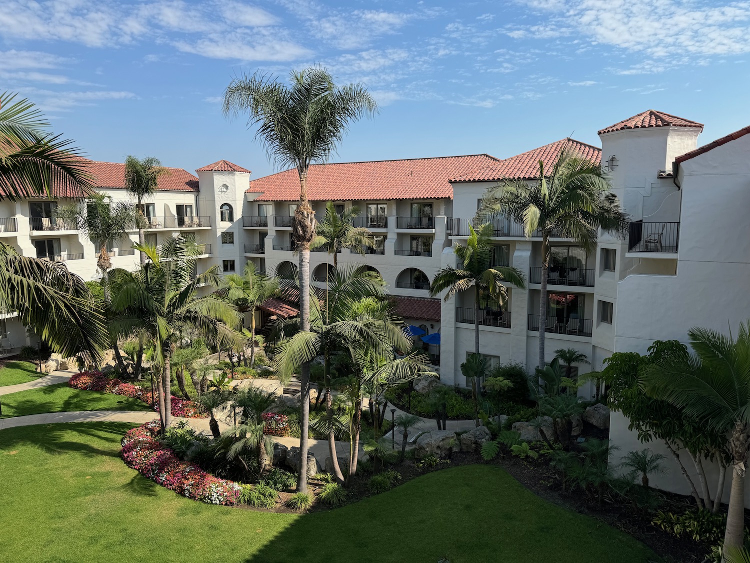 a building with palm trees and a lawn