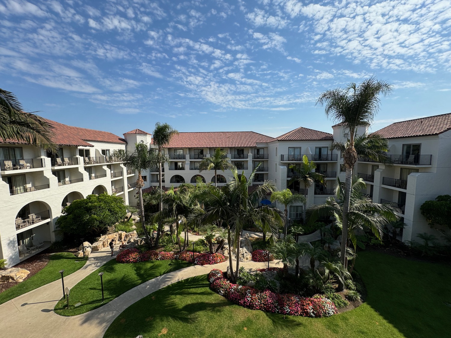 a building with palm trees and a walkway