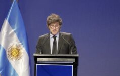 a man standing at a podium with microphones