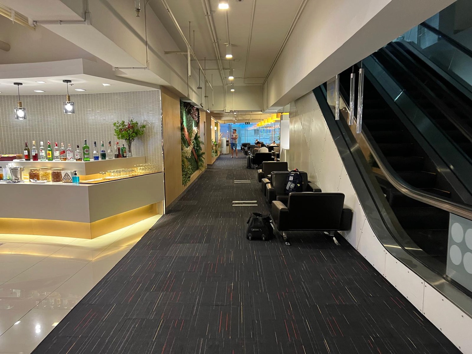 a hallway with escalator and chairs