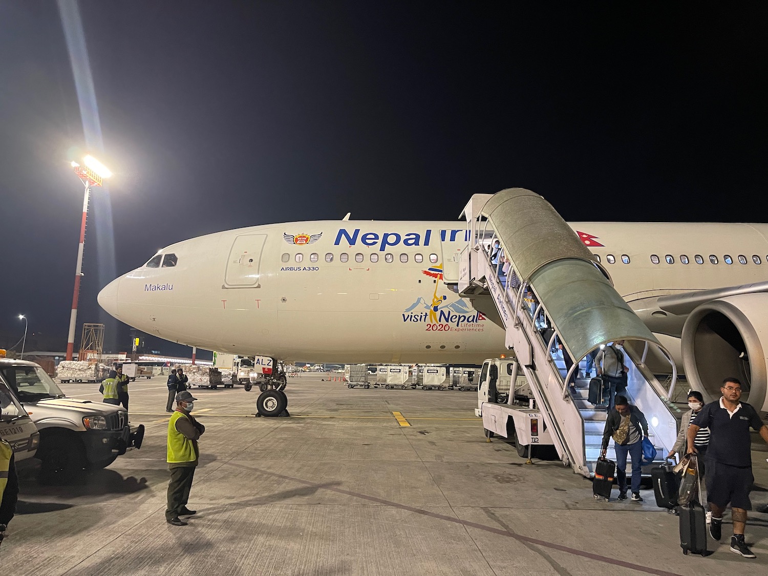 a plane with people boarding stairs