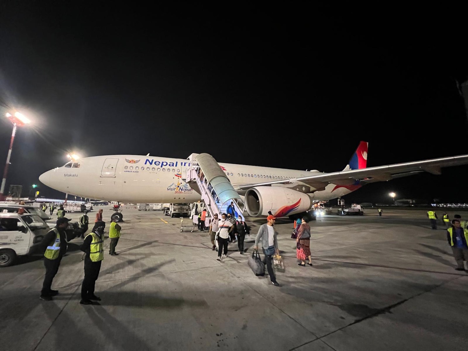 people boarding an airplane at night