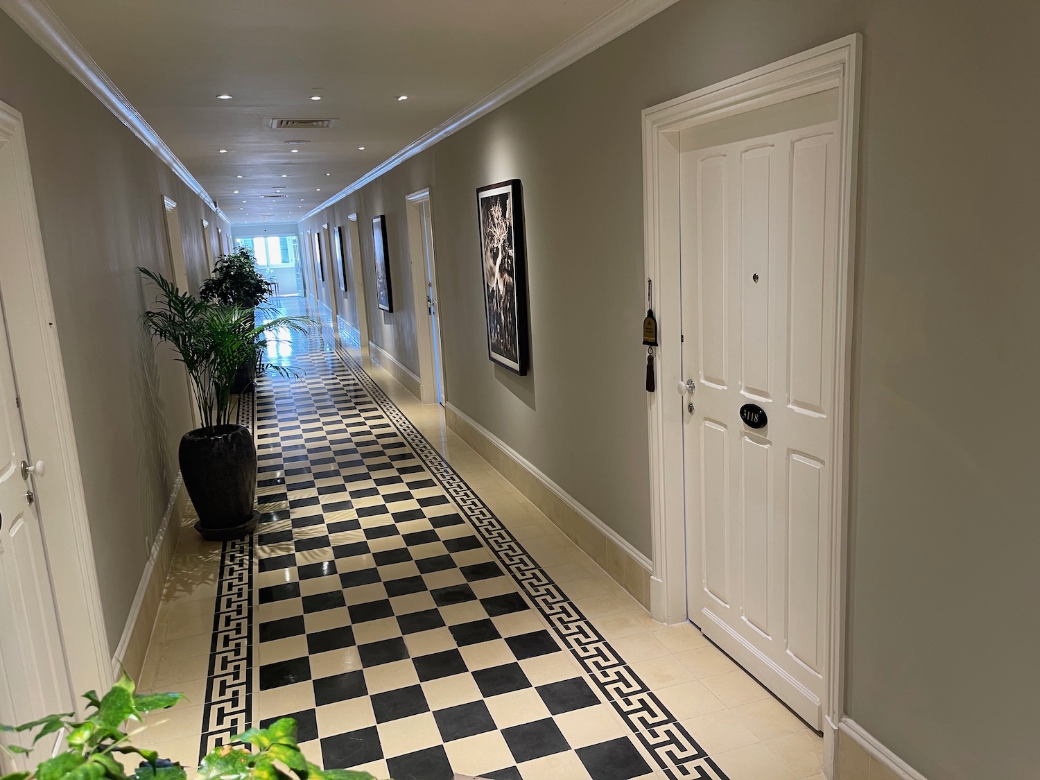 a hallway with a checkered floor and a door