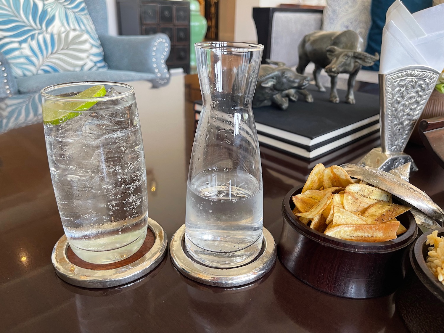 a bowl of potato chips and a glass of water on a table