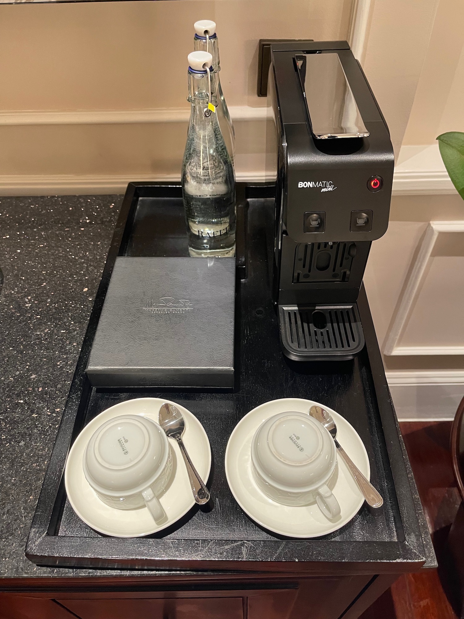 a coffee machine and teacups on a tray