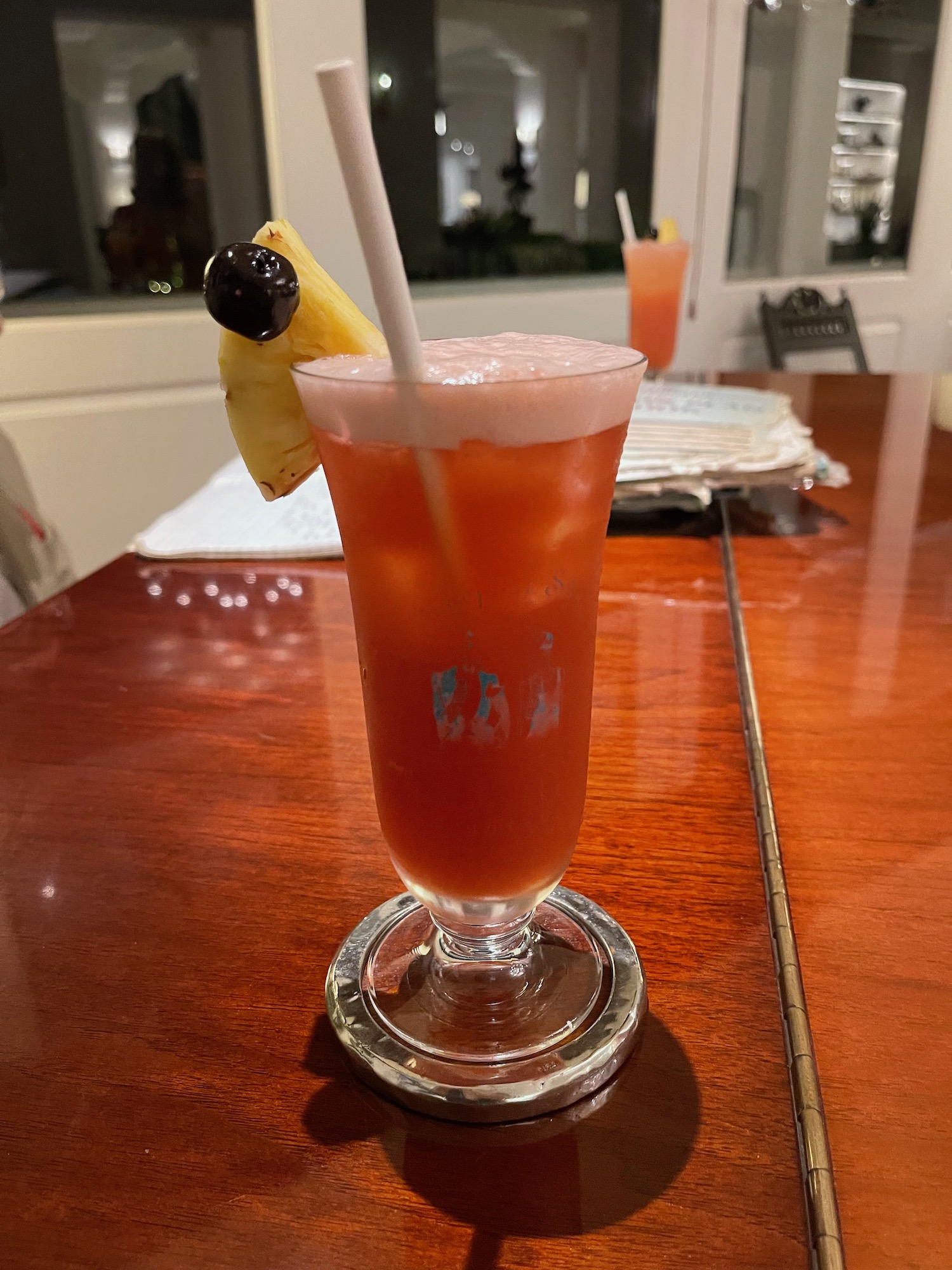 a glass with a drink and a straw on a table