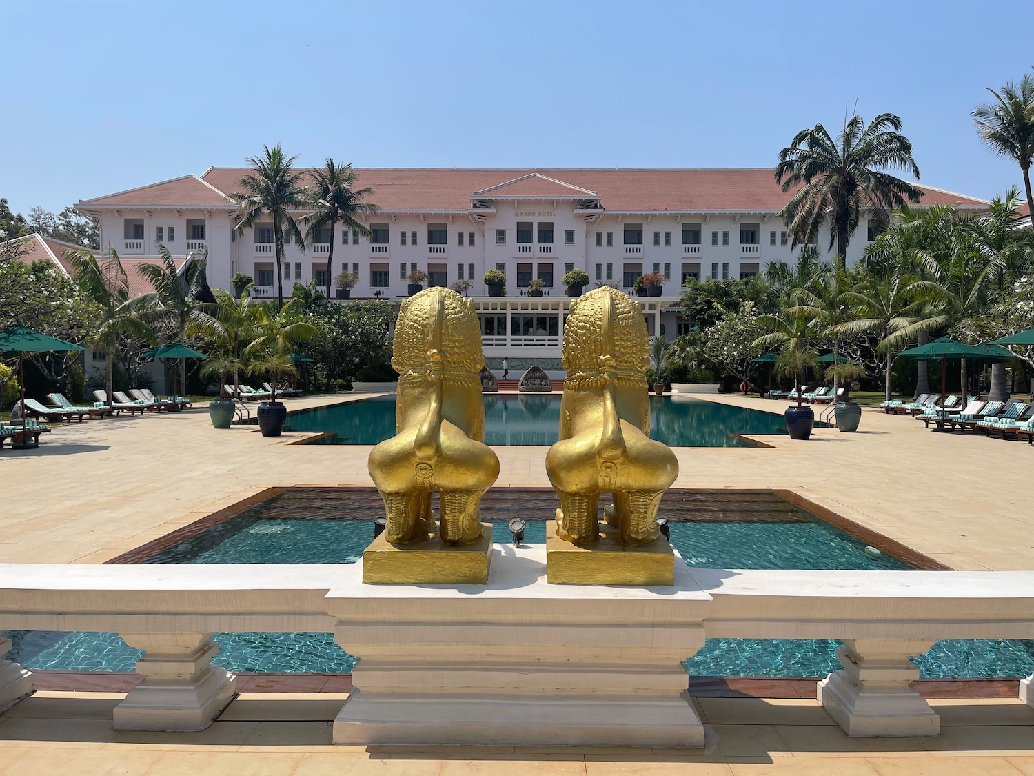 a two gold statues next to a pool