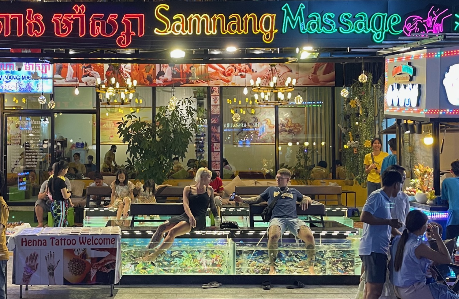 a group of people sitting on a bench in front of a store