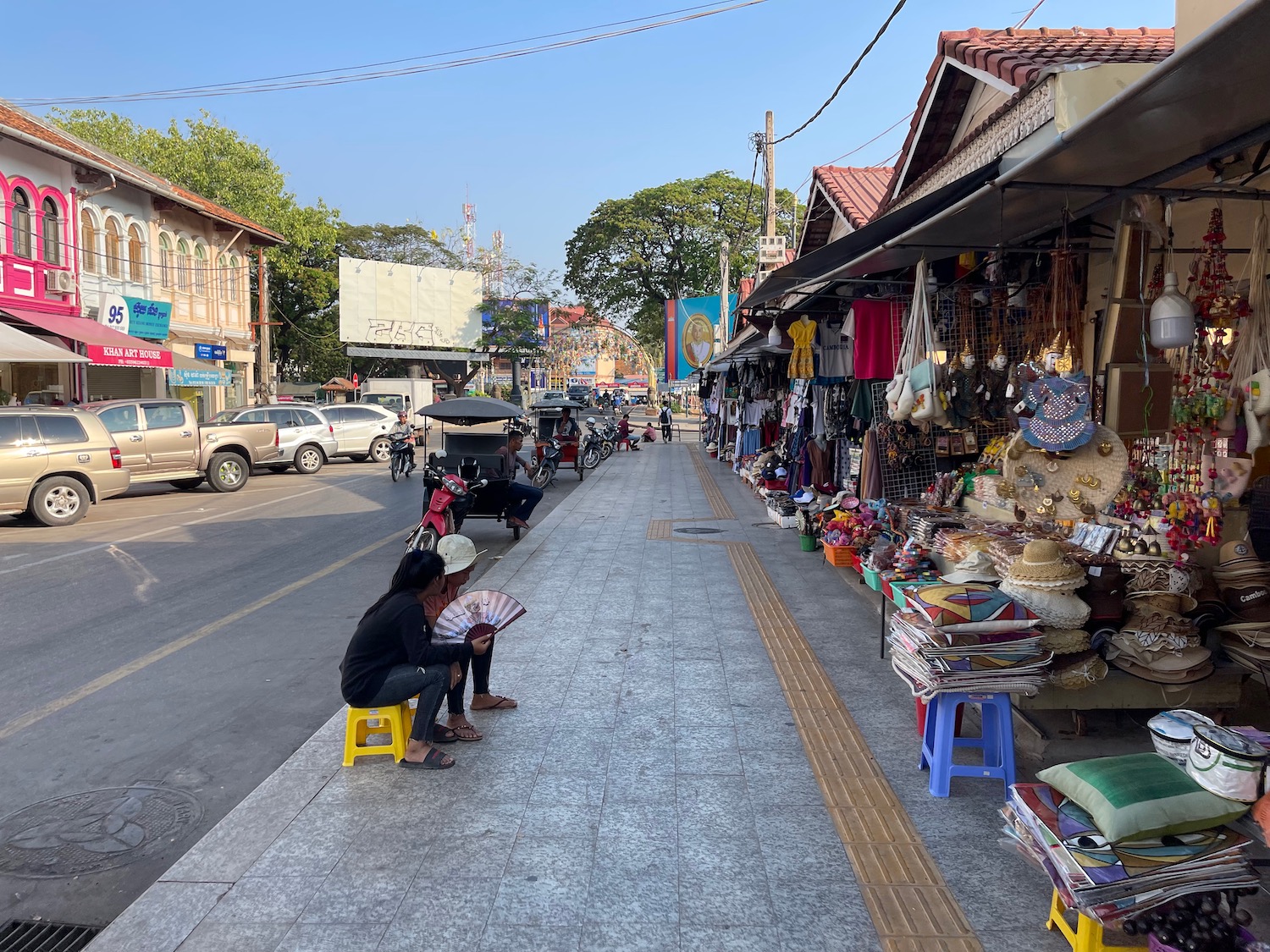 people sitting on a sidewalk with a storefront