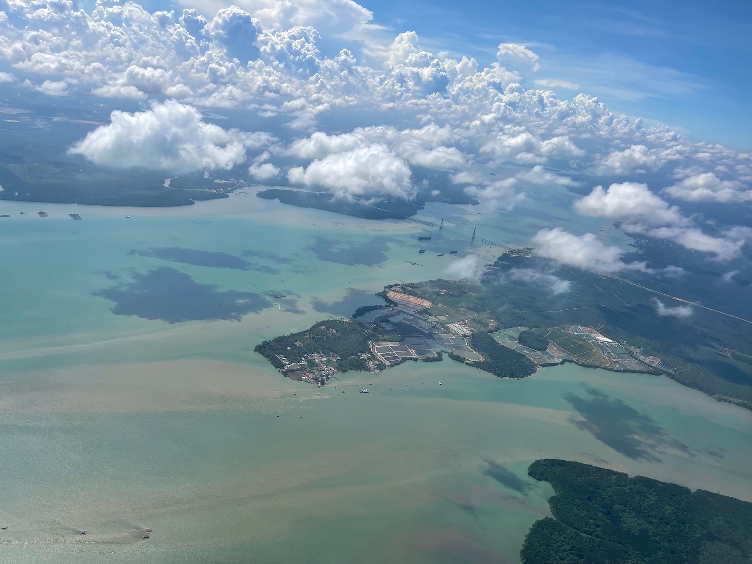 an aerial view of a body of water with land and clouds