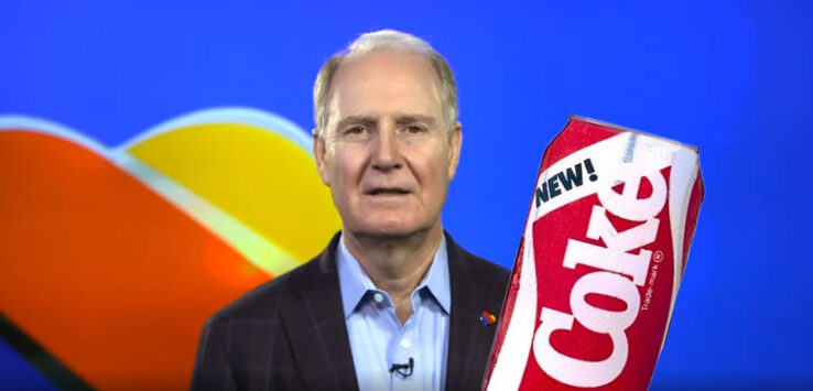 a man in a suit holding a soda