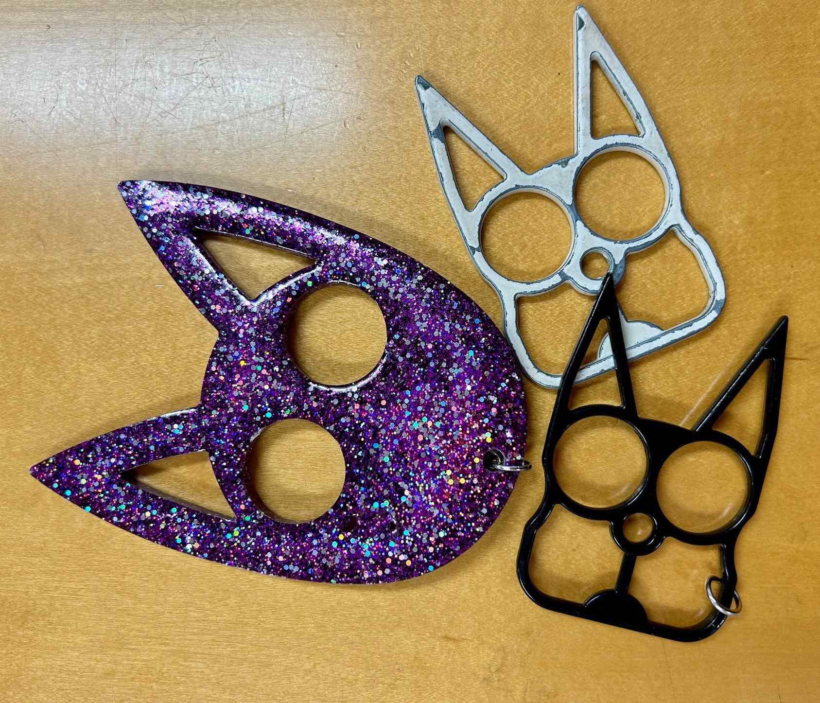 a group of metal cat shaped keychains