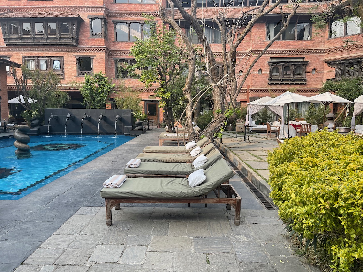 a group of lounge chairs next to a pool